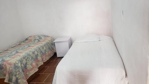 ein kleines Schlafzimmer mit 2 Betten und einem Nachttisch in der Unterkunft Casa Compartida in Guanajuato