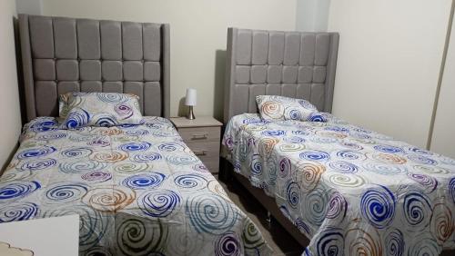 due letti uno accanto all'altro in una camera da letto di Departamento Céntrico y Acogedor a Huancayo