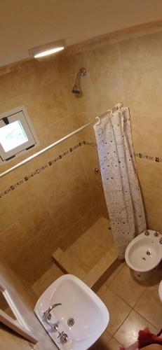 Un baño con lavabo, inodoro y ducha. en Cabaña Challhuaco, en San Carlos de Bariloche
