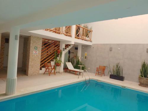 a house with a swimming pool and chairs and a building at El Gamonal - Paracas in Paracas