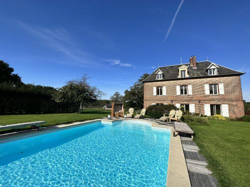 uma grande piscina em frente a uma casa em ailleurs sous les etoiles em Manneville-la-Raoult