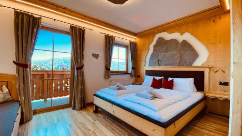a bedroom with a large bed with a large window at Bio Alpenhof Rostatt in Bischofshofen