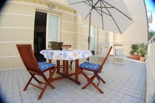 - une table, des chaises et un parasol sur la terrasse dans l'établissement Souvenir 6, à Gabicce Mare