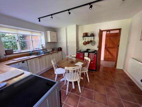 une cuisine avec une table et des chaises dans l'établissement Forestry Cottage. Hot tub, open fire, dog friendly, à Gaywood
