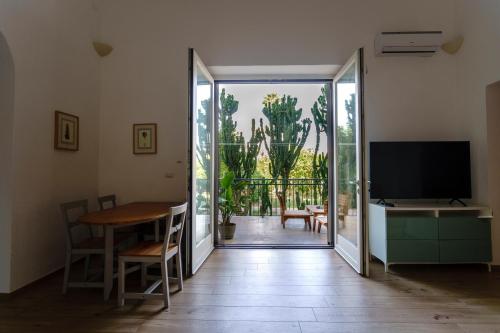 a living room with a sliding glass door and a television at La Bella Lecce Apartment in Lecce
