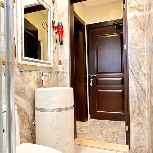 a bathroom with a toilet and a brown door at منتجع اووه يامال البحري في الخيران OOh Yaa Mal in Al Khīrān