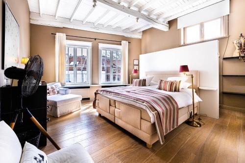 a bedroom with a bed and a large window at Maison Amodio in Bruges