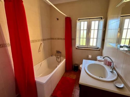 uma casa de banho com uma banheira e um lavatório e uma banheira em Tapada dos Ribeiros no Alpalhão