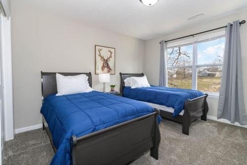 1 dormitorio con 2 camas y ventana en Home among the Nook in Hamilton Ohio, en Hamilton