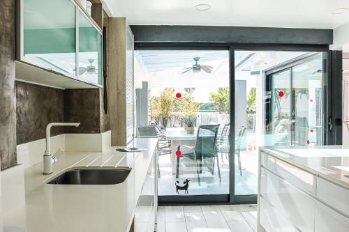 een keuken met een wastafel en een eetkamer bij Villa Stefy by Bedzy in Galé