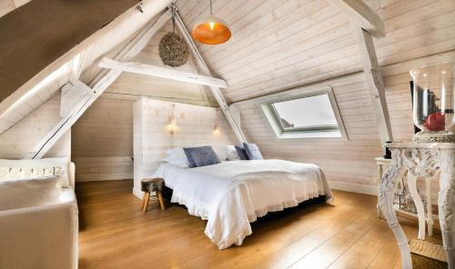 een slaapkamer met een wit bed op zolder bij Maison Amodio in Brugge