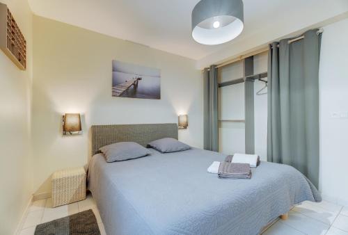 una camera da letto con un grande letto con lenzuola blu di Grain de sable a Saint-Benoît-des-Ondes