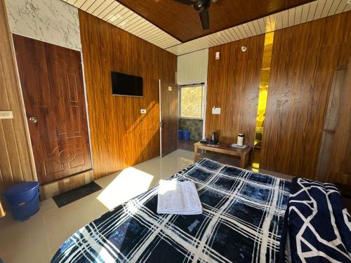 een slaapkamer met een bed en een tv. bij Kanatal's Valley View INN in Kanatal