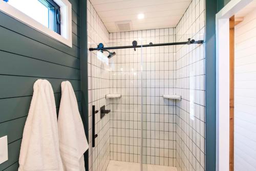 a bathroom with a shower with white tiles at The Meadows Shipping Container Home in Bellmead