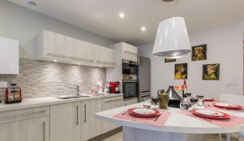 a kitchen with white cabinets and a white counter top at Le Clos Savoie Lorraine in Thônes