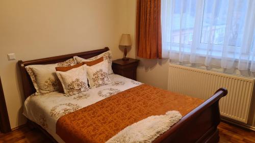 a bedroom with a bed with pillows and a window at Apartament Bogdan in Gura Humorului