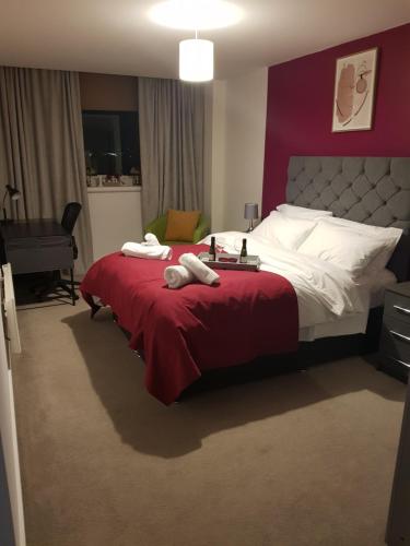 a bedroom with a large bed with a red blanket at Stunning 1-Bed Apartment in Brierley Hill in Dudley