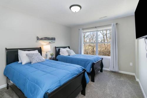 2 camas en un dormitorio con ventana en Brand NEW home among the Nook in Hamilton, Ohio, en Hamilton