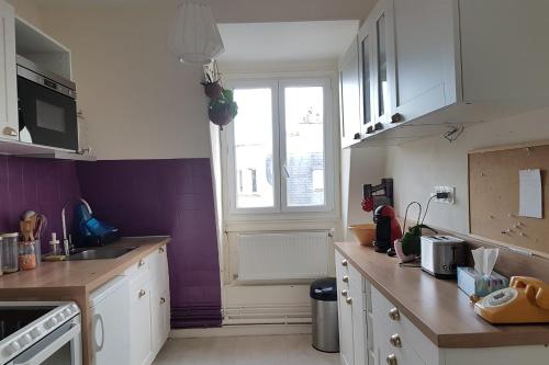 una cocina con armarios blancos y una ventana en Luxurious Apartment Near Parc André Citröen, en París