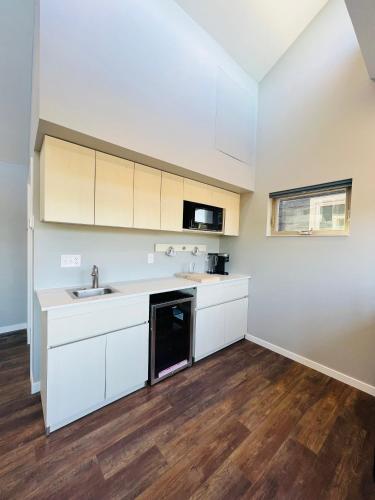 an empty kitchen with white cabinets and a sink at EXPLORE: Munising Alger Falls in Munising