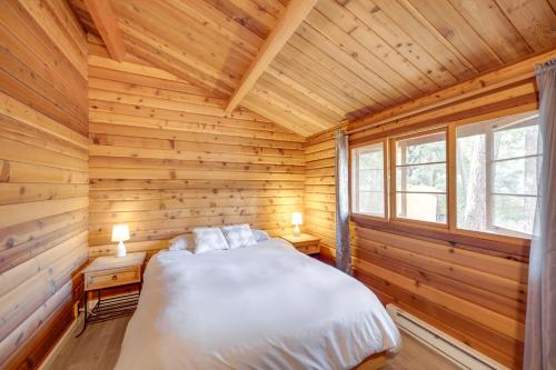 een slaapkamer met een bed in een houten hut bij Pine Mountain Club Cabin Near Ferns Lake! in Frazier Park