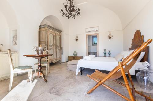 a bedroom with a bed and a table and a chair at Ca` della Roccia by Perle di Puglia in Ostuni