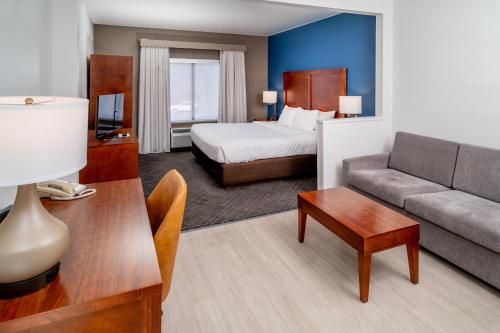 a hotel room with a bed and a couch at Comfort Suites Prestonsburg West in Prestonsburg