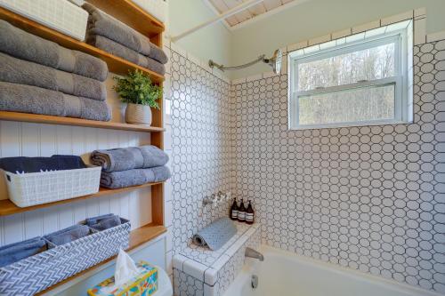 ein Bad mit einer Badewanne, einem Fenster und Handtüchern in der Unterkunft Idyllic Blue Ridge Mountain Home on 26-Acre Farm in Roan Mountain