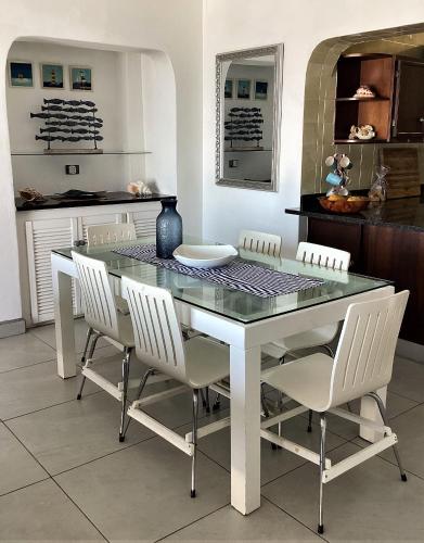 a dining room with a glass table and white chairs at Nomads Nook 15 in Ramsgate