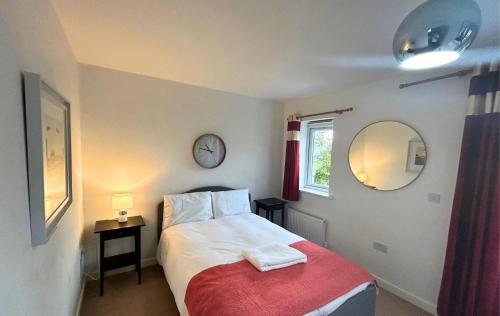 a bedroom with a bed with two towels on it at Addlestone and Chertsey Stylish and Modern 4 bedroom 4 bathroom Townhouse in Addlestone