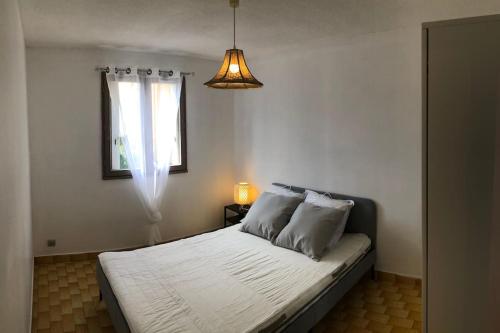 une chambre avec un lit blanc avec une fenêtre dans l'établissement Cap d’Agde Beau 2 pièces plage commerces à pieds !, au Cap d'Agde
