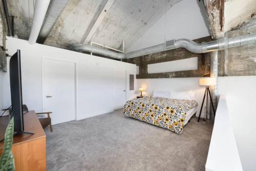 an attic bedroom with a bed and a tv at Peters Cartridge Factory in Maineville