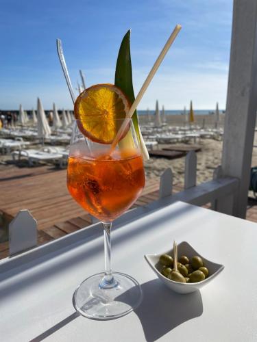 - une boisson assise sur une table à côté d'un bol d'olives dans l'établissement Cap d’Agde Beau 2 pièces plage commerces à pieds !, au Cap d'Agde