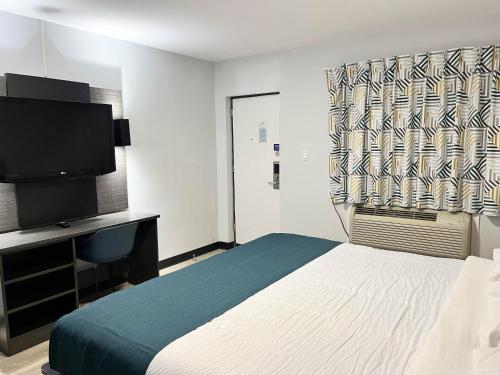 1 dormitorio con 1 cama y TV de pantalla plana en Motel 6 Williamstown, NJ Black Horse Pike, en Williamstown