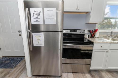 a stainless steel refrigerator in a kitchen with white cabinets at New renovated single-family home built in 1999 in Middletown