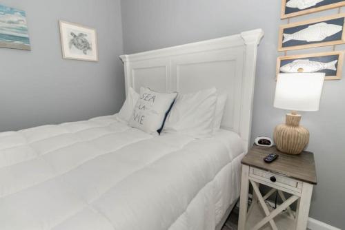 a white bedroom with a white bed and a table at New renovated single-family home built in 1999 in Middletown