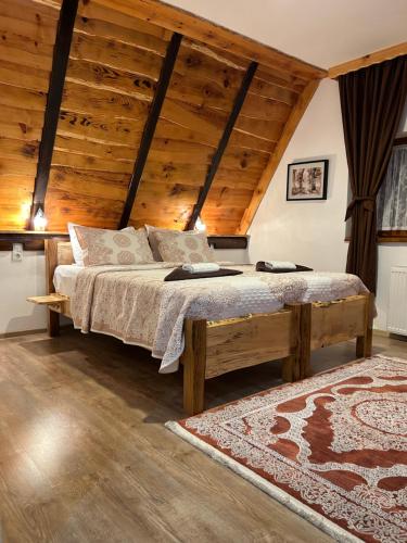 a bedroom with a large bed with a wooden ceiling at Rustic Lodge Plitvice in Plitvička Jezera