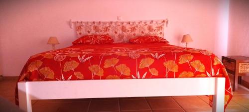 un letto con piumone rosso e 2 cuscini rossi di Stella Maris Da Costa Apartament a Calheta Do Maio