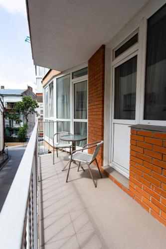 a patio with a table and chairs on a balcony at Центр. Вул. Родини Барвінських in Ternopilʼ