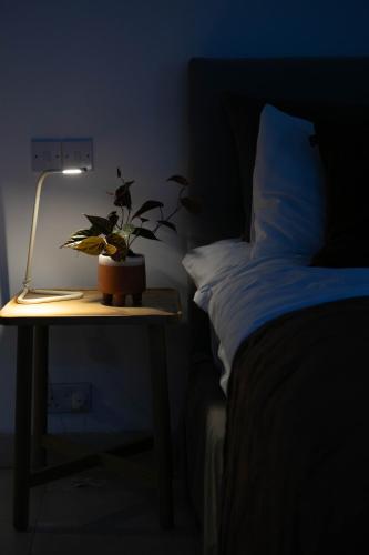a night stand with a plant on a table next to a bed at The Luxury Inn in London