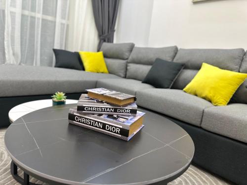 a pile of books sitting on a coffee table in a living room at Luxury 2 bedroom new brand in Ajman 