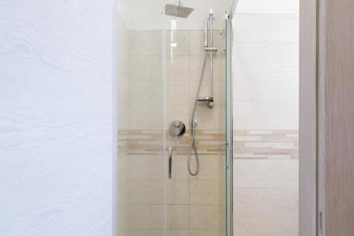 een badkamer met een douche en een glazen deur bij Appartamento-Sanremo my Home Free parking-Wi-fi in Sanremo