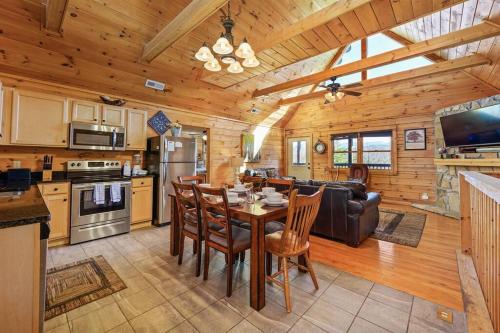 uma cozinha e sala de estar com mesa e cadeiras em Spacious Smokies Cabin - Hot Tub with Mountain Views em Gatlinburg