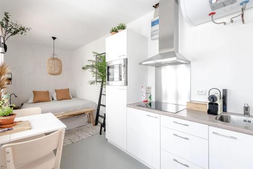 een kleine keuken met witte kasten en een bank bij Beach appartment Alexy Zandvoort in Zandvoort