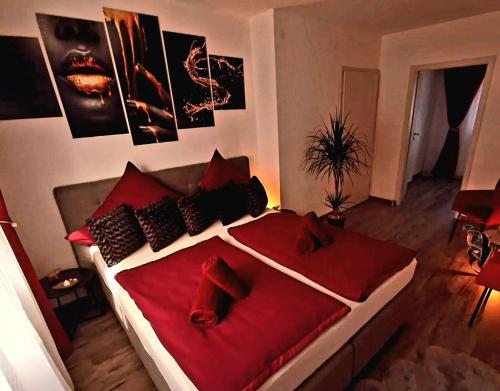 1 dormitorio con 1 cama con sábanas y almohadas rojas en Mefady Ferienhaus mit Massagesessel en Stadtkyll