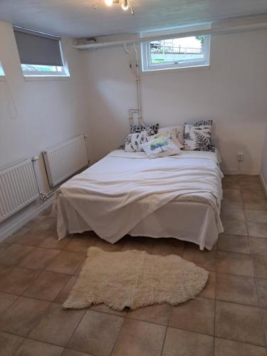 a bedroom with a large bed in a room with windows at Lägenhet Huskvarna in Jönköping