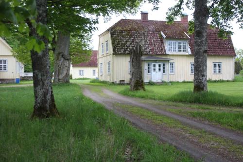 a dirt road in front of a house with trees at Yxkullsund Säteri B&B - Manor & Estate since 1662 in Lagan