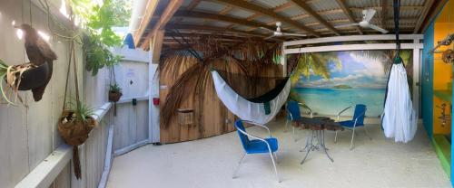 Cette chambre dispose d'une terrasse avec une table et des chaises. dans l'établissement LES HAMACS AUX SAINTES BIS, à Terre-de-Haut