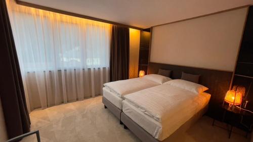 a bedroom with a white bed and a window at Penzión Holub in Banská Bystrica