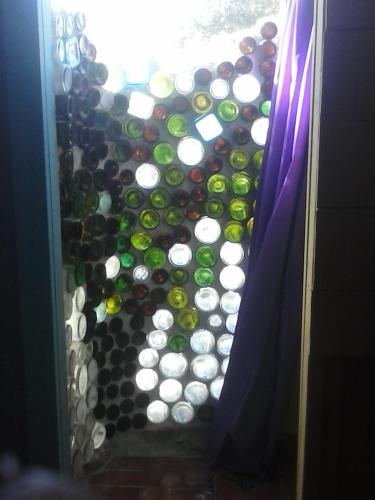 a room with a bunch of bottles of wine at Anda Di Hows Hostel in Placencia Village